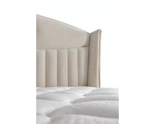 Elegant bed with pillow in light beige fabric and wood