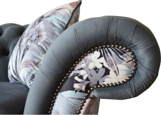 A striking three-seater sofa in Chesterfield design with delicate gray floral decoration.