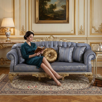Sophisticated classic sofa in Chesterfield design for the living room with golden cushions.