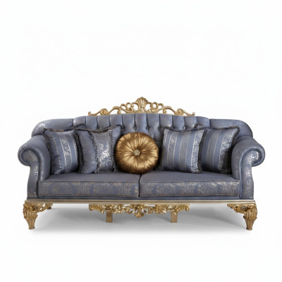 Sophisticated classic sofa in Chesterfield design for the living room with golden cushions.